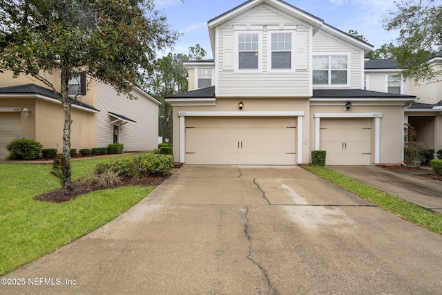 view of front facade featuring a garage, a front lawn, and concrete driveway