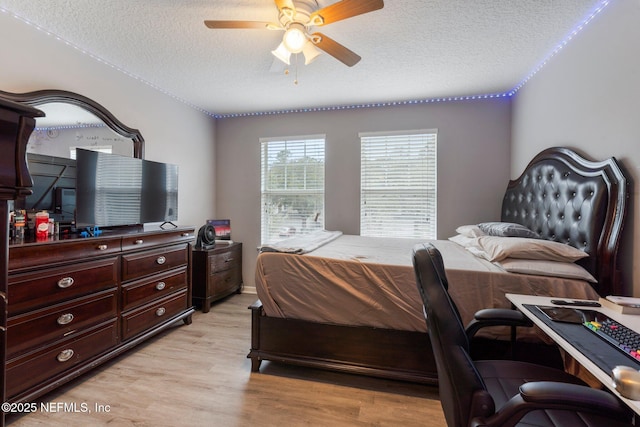 bedroom with a ceiling fan, light wood-style flooring, and a textured ceiling