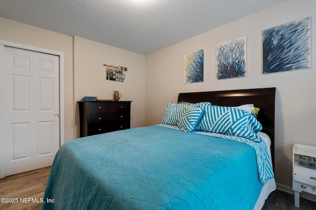 bedroom featuring a textured ceiling and wood finished floors