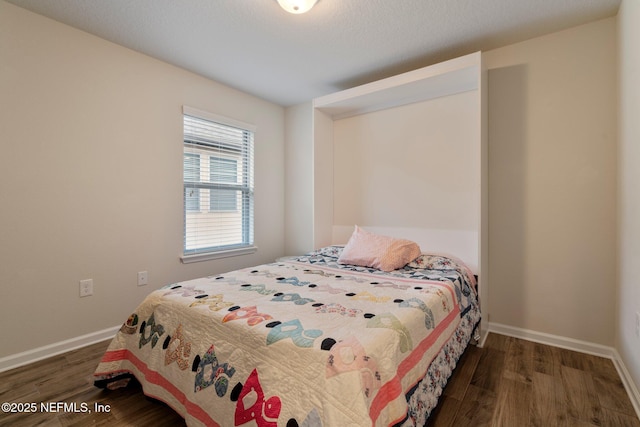 bedroom with dark wood-style floors and baseboards