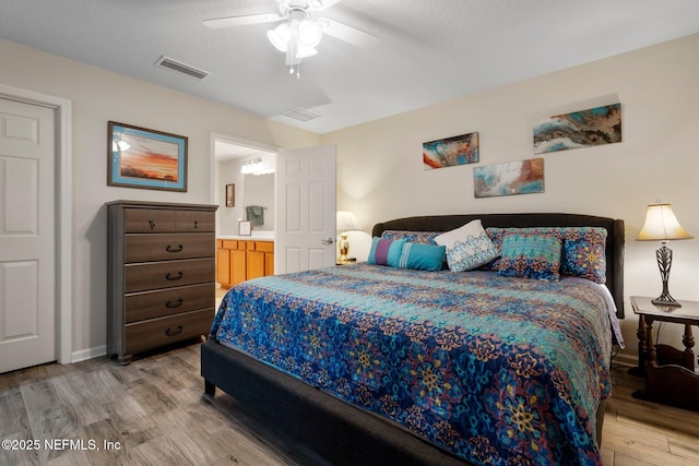 bedroom with a ceiling fan, visible vents, light wood-style flooring, and a textured ceiling