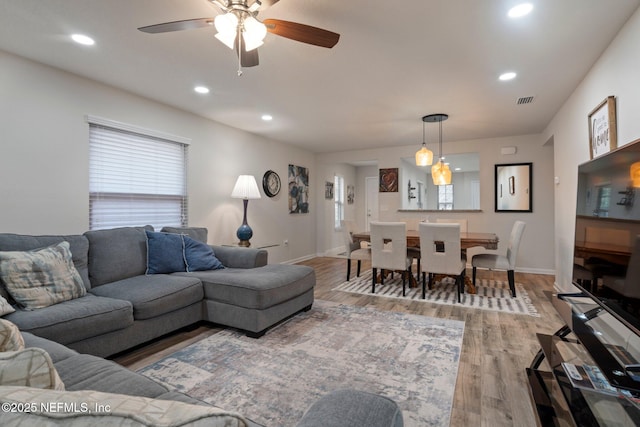 living room featuring recessed lighting, visible vents, baseboards, and wood finished floors