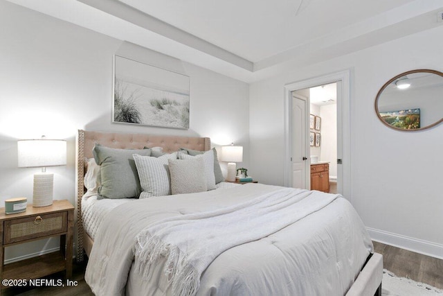 bedroom featuring ensuite bathroom and dark hardwood / wood-style flooring