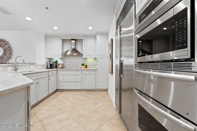 kitchen with white cabinetry, sink, decorative backsplash, and wall chimney exhaust hood