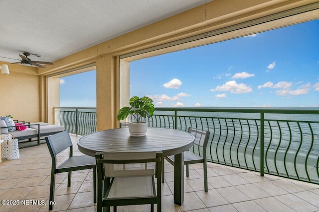 balcony featuring a water view and ceiling fan