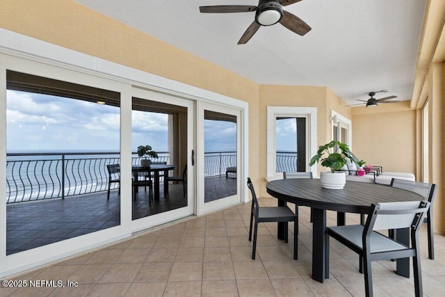 sunroom / solarium with a water view and ceiling fan