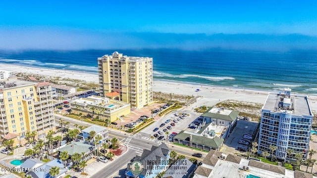 birds eye view of property featuring a water view and a beach view