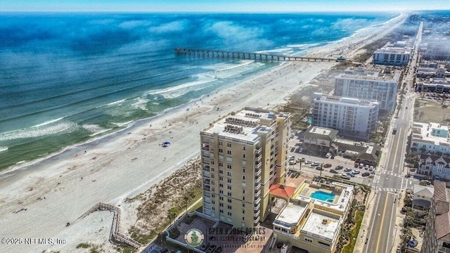 drone / aerial view featuring a water view and a view of the beach