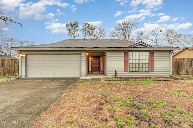 ranch-style house featuring an attached garage, fence, and concrete driveway