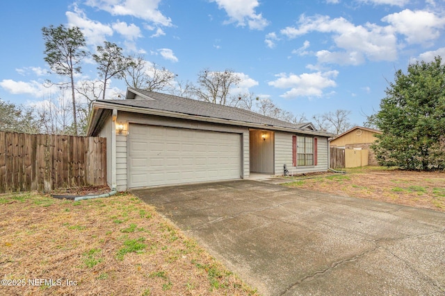 ranch-style home featuring driveway, an attached garage, and fence