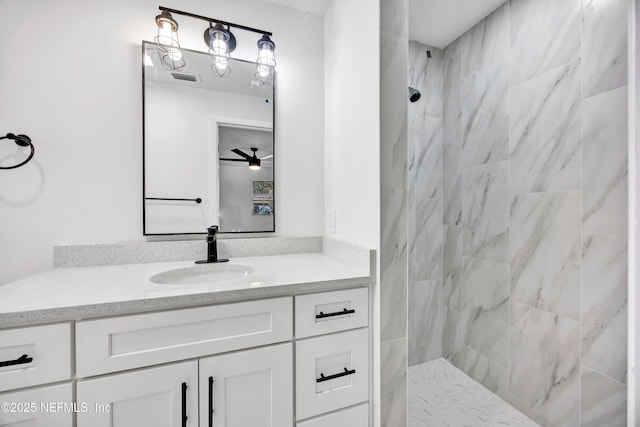 bathroom featuring a tile shower and vanity