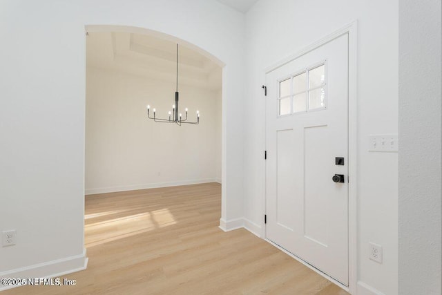 entrance foyer with hardwood / wood-style flooring and a notable chandelier