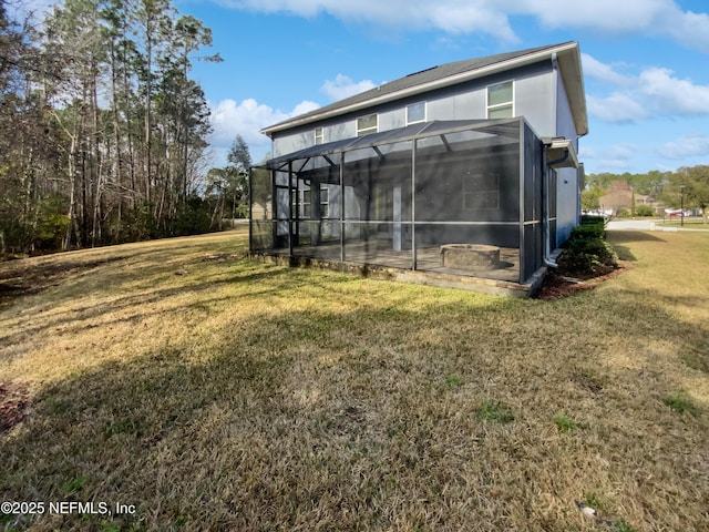 rear view of property with a lawn and glass enclosure