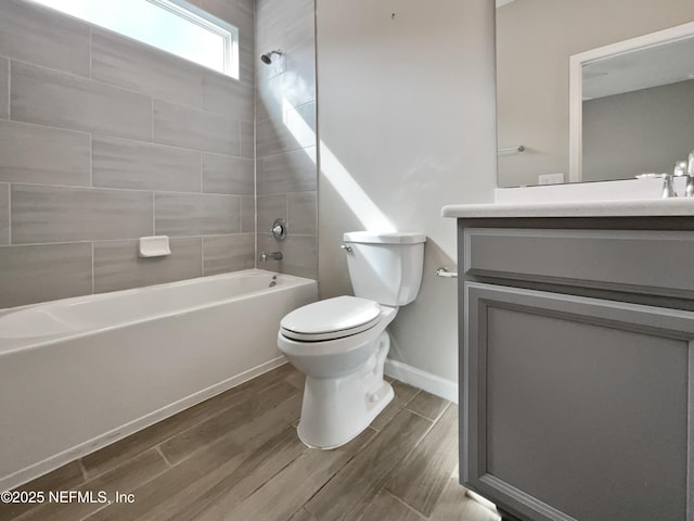 full bathroom with tiled shower / bath, wood-type flooring, vanity, and toilet