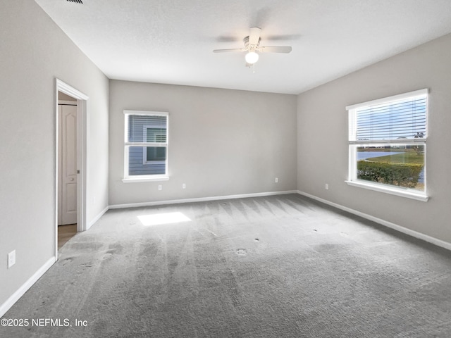 carpeted spare room featuring ceiling fan and a textured ceiling