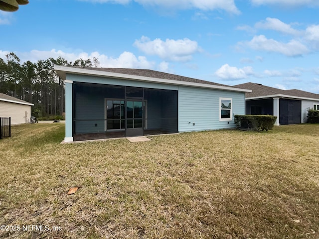 back of house featuring a yard and a sunroom