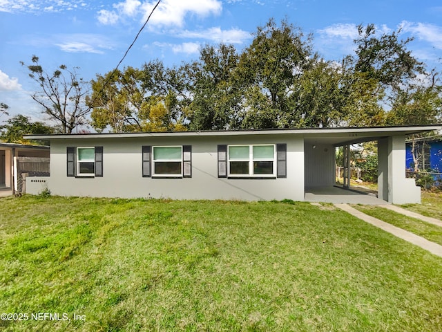 single story home featuring a carport, a front yard, and stucco siding