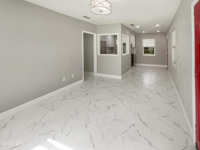 spare room with marble finish floor, recessed lighting, visible vents, and baseboards