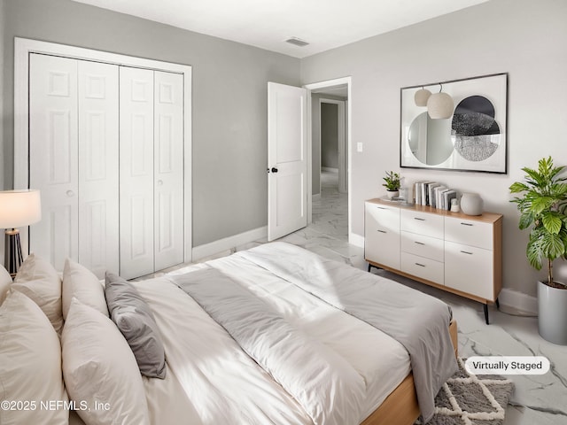 bedroom with a closet, marble finish floor, visible vents, and baseboards