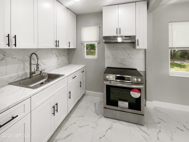 kitchen featuring decorative backsplash, white cabinets, under cabinet range hood, stainless steel range with electric stovetop, and a sink