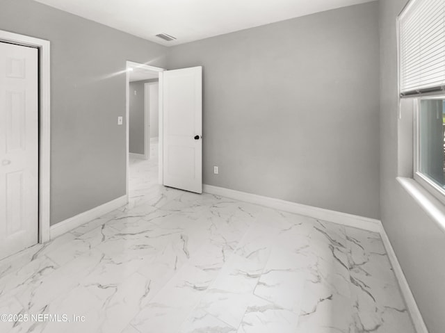 unfurnished room featuring marble finish floor, visible vents, and baseboards