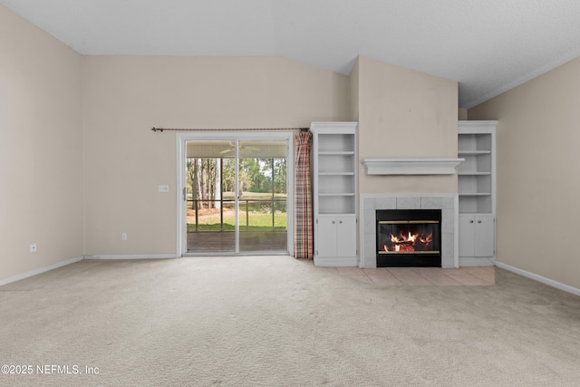 unfurnished living room with baseboards, lofted ceiling, carpet, and a fireplace