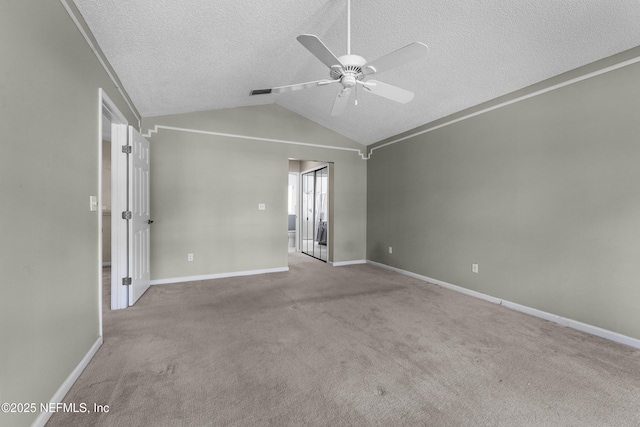 carpeted empty room with baseboards, ceiling fan, a textured ceiling, and lofted ceiling