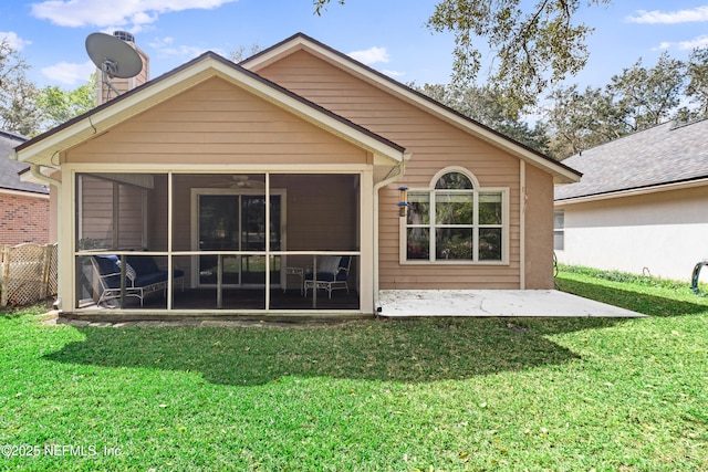 rear view of property with a lawn and a sunroom