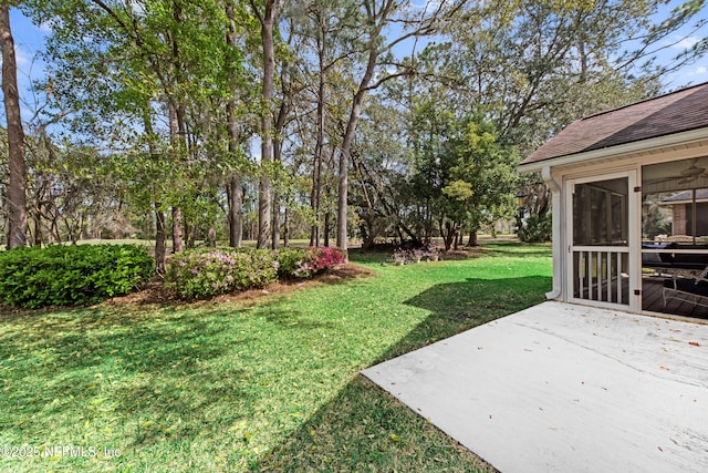 view of yard with a sunroom and a patio area