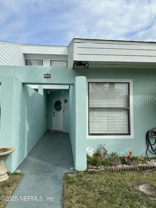 property entrance with stucco siding