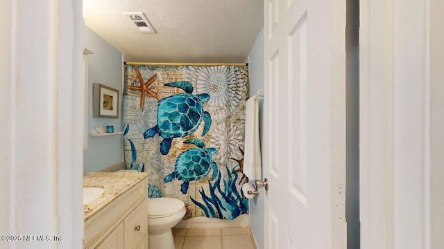 bathroom featuring visible vents, toilet, a textured ceiling, vanity, and tile patterned floors