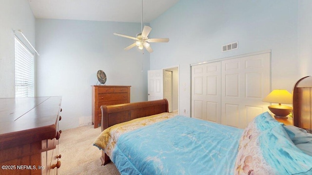 carpeted bedroom with high vaulted ceiling, a closet, visible vents, and a ceiling fan