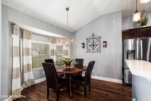 dining area featuring dark wood-type flooring and vaulted ceiling