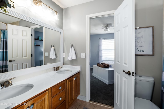 bathroom with tile patterned flooring, vanity, ceiling fan, and toilet