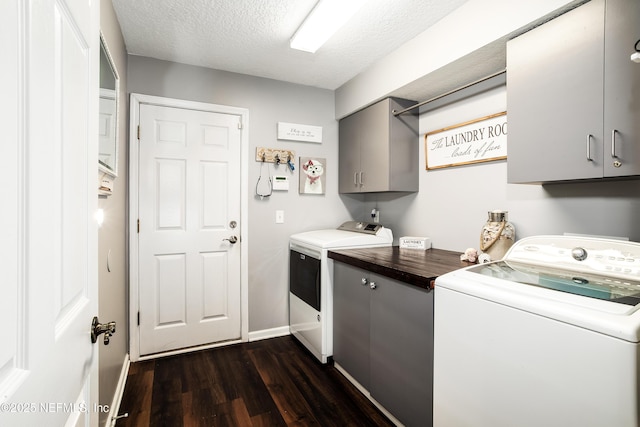 laundry room with cabinets, dark hardwood / wood-style flooring, separate washer and dryer, and a textured ceiling