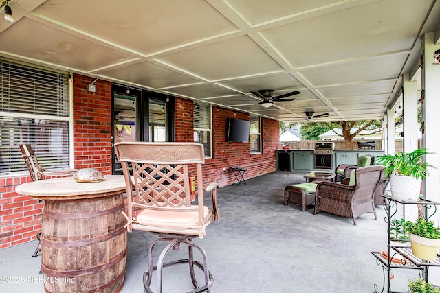 view of patio / terrace featuring a grill, ceiling fan, and exterior kitchen