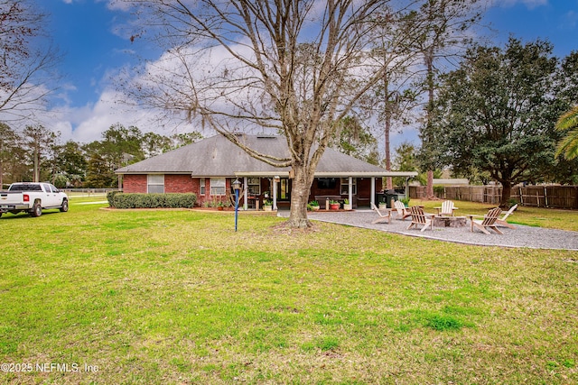 back of house featuring a yard, a patio, and an outdoor fire pit