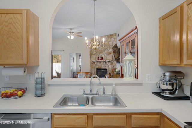 kitchen with a fireplace, hanging light fixtures, sink, dishwasher, and light brown cabinets