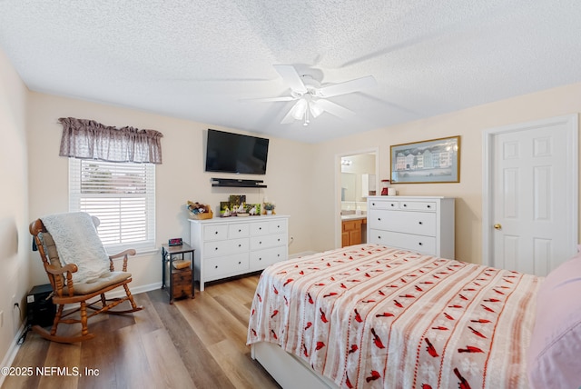 bedroom featuring light hardwood / wood-style floors, ceiling fan, and a textured ceiling