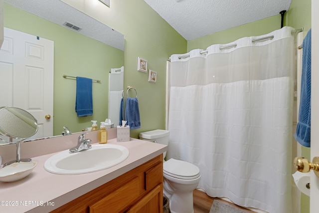 bathroom with toilet, vanity, and a textured ceiling