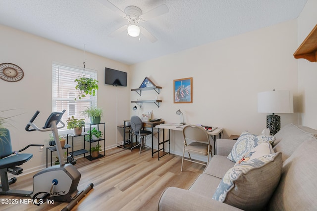 interior space with ceiling fan, light wood-type flooring, and a textured ceiling