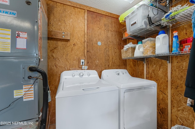 laundry room featuring washing machine and dryer and wood walls