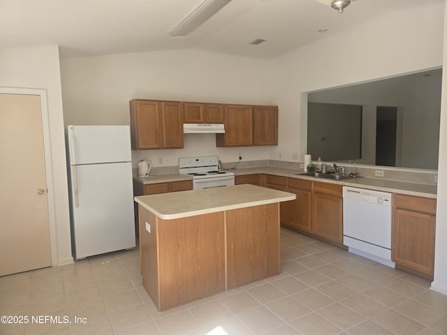 kitchen featuring sink, white appliances, a center island, light tile patterned flooring, and vaulted ceiling