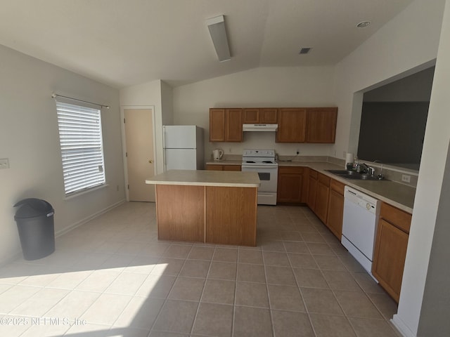 kitchen with white appliances, vaulted ceiling, light tile patterned flooring, and a kitchen island