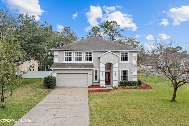 traditional home featuring a garage, concrete driveway, fence, a front yard, and stucco siding