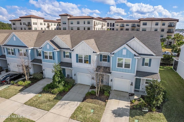 townhome / multi-family property featuring a residential view, board and batten siding, and a shingled roof