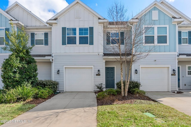 townhome / multi-family property featuring a garage, board and batten siding, and driveway