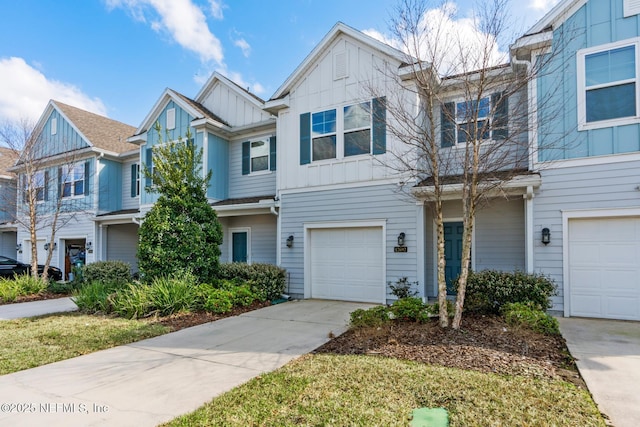 townhome / multi-family property with board and batten siding, concrete driveway, and a garage