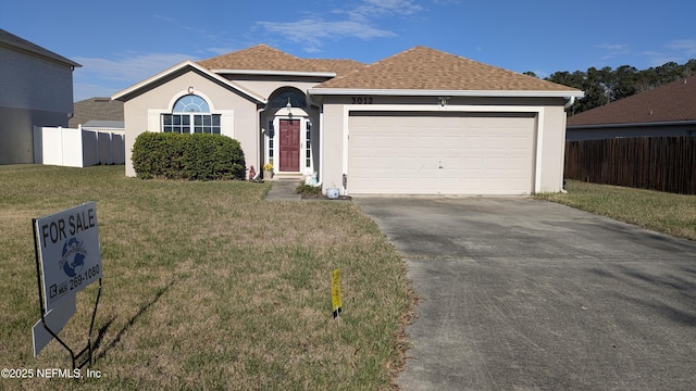 ranch-style home with an attached garage, fence, concrete driveway, stucco siding, and a front yard