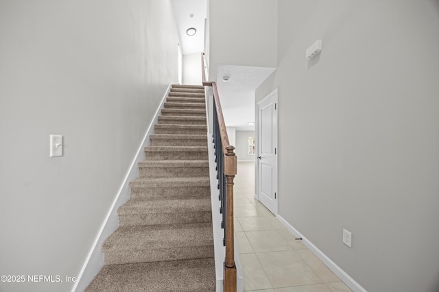 stairway featuring baseboards and tile patterned floors